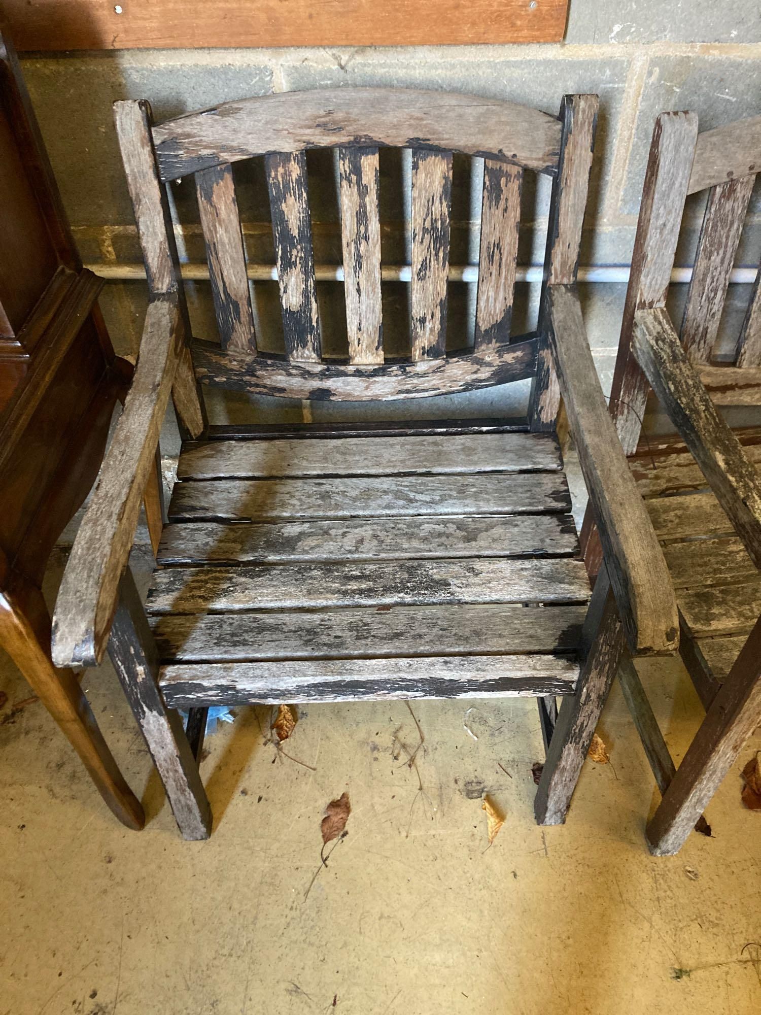 Two stained teak garden benches and matching armchairs, bench widths 126cm and 123cm